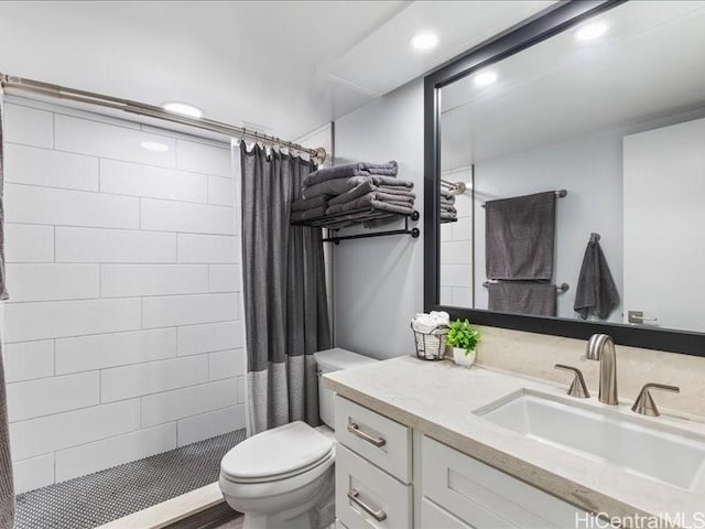 bathroom featuring toilet, vanity, and curtained shower