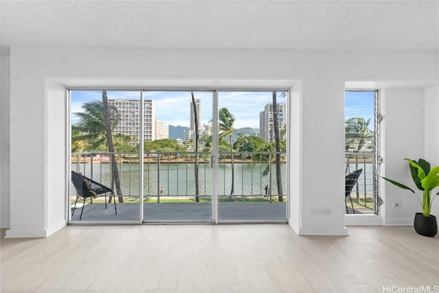 entryway with a water view and a textured ceiling