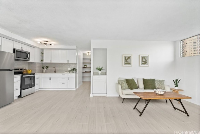 living room with light wood-type flooring, breakfast area, and sink