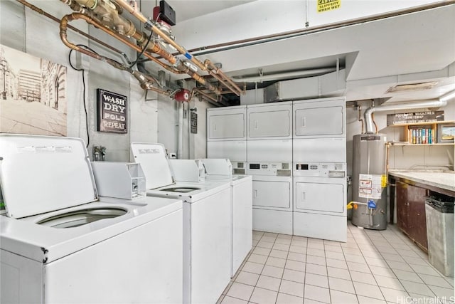 laundry area with light tile patterned flooring, gas water heater, stacked washing maching and dryer, and washing machine and dryer