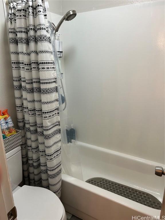 bathroom with shower / tub combo and toilet