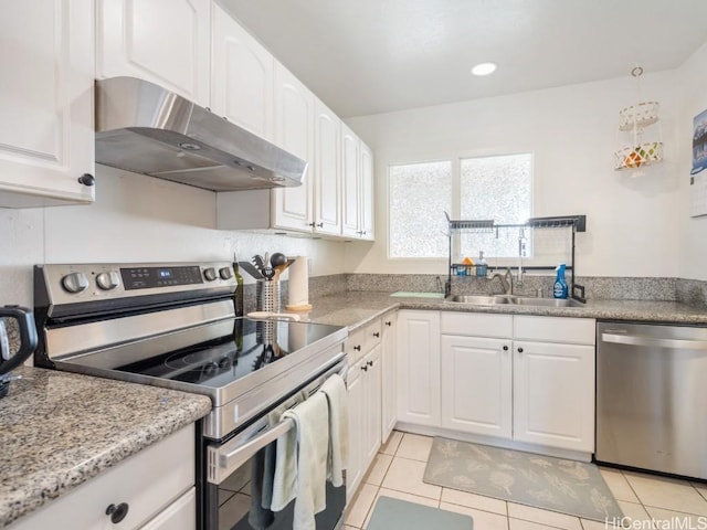 kitchen featuring white cabinets, light tile patterned floors, sink, and appliances with stainless steel finishes