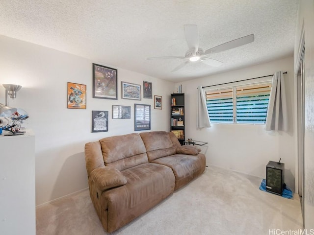 carpeted living room featuring ceiling fan and a textured ceiling