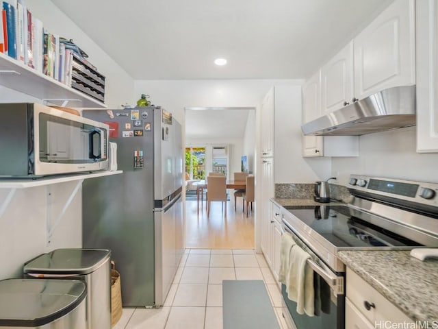 kitchen with white cabinetry, light tile patterned floors, light stone countertops, and appliances with stainless steel finishes