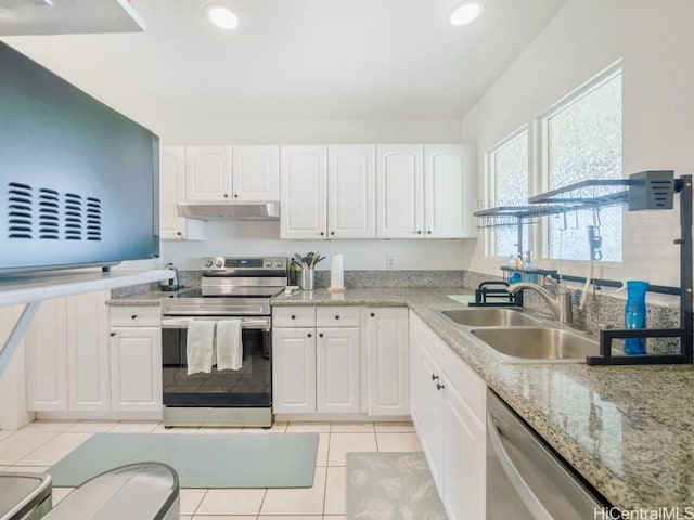 kitchen featuring white cabinets, appliances with stainless steel finishes, light tile patterned floors, and sink