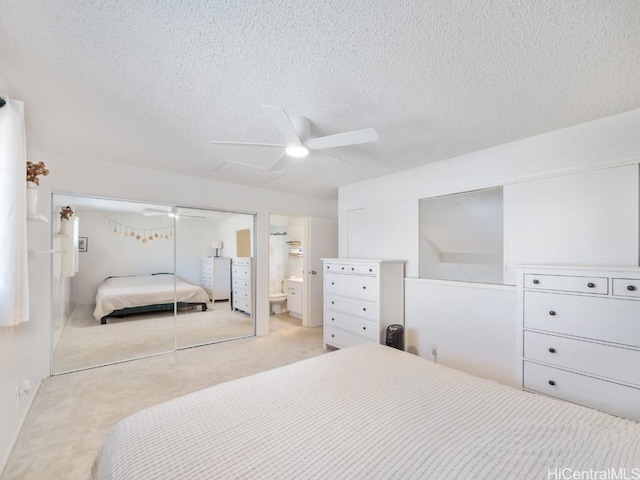 carpeted bedroom featuring ceiling fan, a textured ceiling, connected bathroom, and a closet