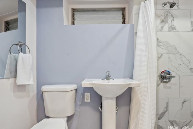 bathroom with toilet and a shower with shower curtain