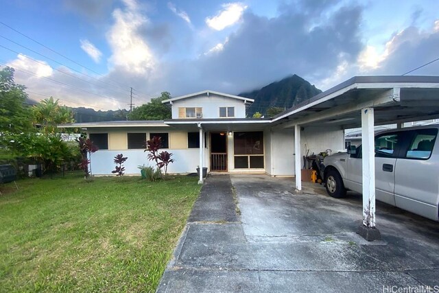 view of front facade featuring a front yard and a carport