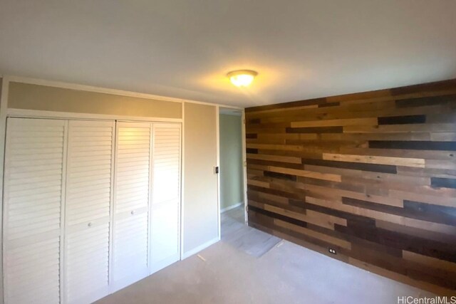 unfurnished bedroom featuring wood walls and a closet