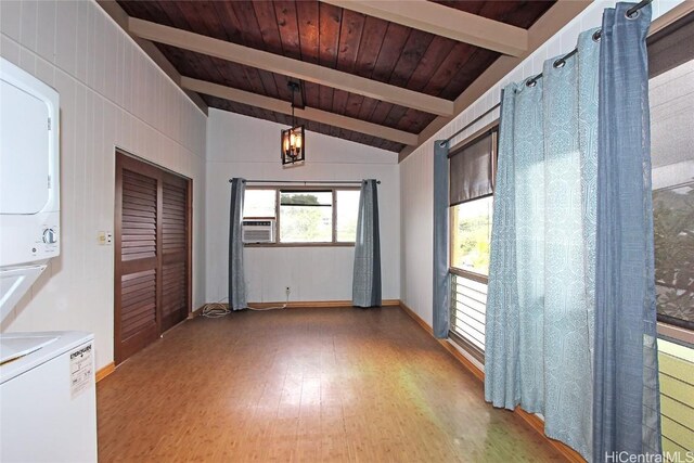 empty room featuring stacked washer and clothes dryer, cooling unit, vaulted ceiling with beams, wood-type flooring, and wood ceiling