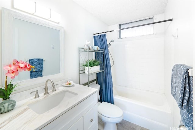 full bathroom featuring toilet, vanity, shower / bath combination with curtain, and a textured ceiling