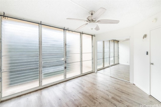 unfurnished room featuring ceiling fan, a textured ceiling, and light hardwood / wood-style flooring