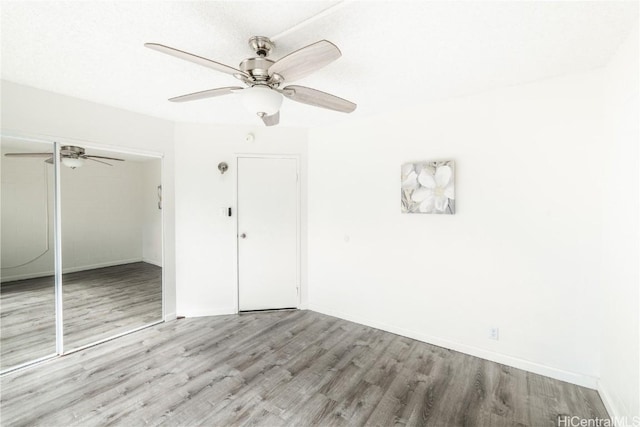 unfurnished bedroom featuring ceiling fan, a closet, and light hardwood / wood-style floors