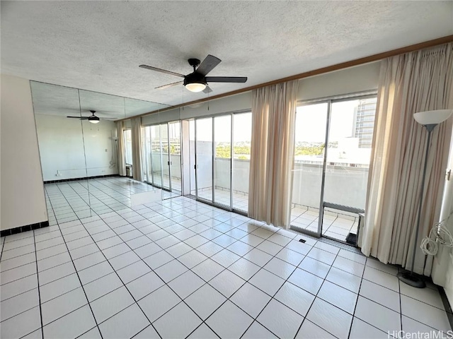 unfurnished room featuring a textured ceiling, ceiling fan, and light tile patterned floors