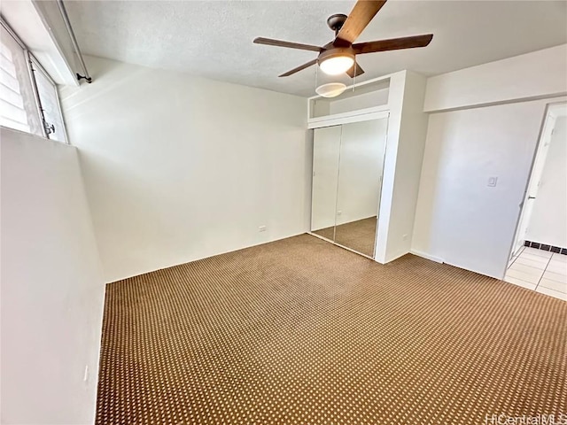 unfurnished bedroom featuring ceiling fan, a closet, and a textured ceiling