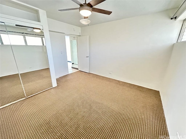 unfurnished bedroom with carpet flooring, ceiling fan, and a closet