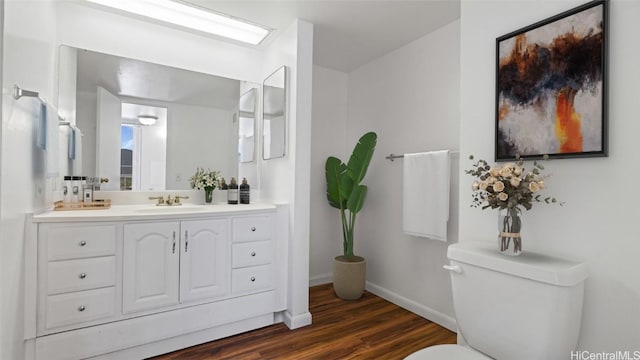 bathroom with vanity, toilet, and wood-type flooring