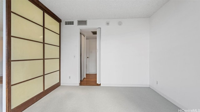 unfurnished bedroom with light carpet and a textured ceiling