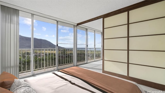 bedroom featuring a mountain view and a textured ceiling