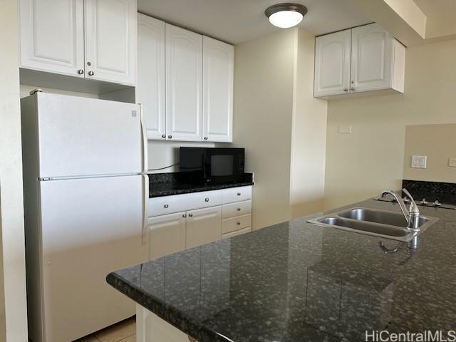 kitchen with white fridge, sink, and white cabinetry