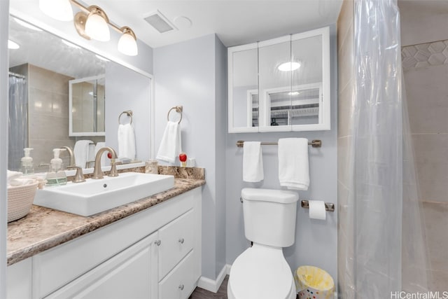 bathroom with toilet, vanity, and a shower with curtain