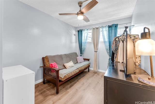 sitting room featuring ceiling fan, a textured ceiling, and light hardwood / wood-style floors