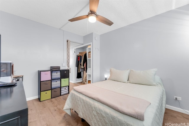 bedroom featuring a textured ceiling, a closet, light hardwood / wood-style floors, and ceiling fan