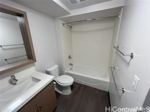 full bathroom featuring toilet, wood-type flooring, vanity, and washtub / shower combination