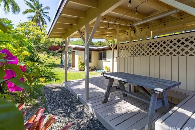 wooden deck with a lawn and outdoor dining area