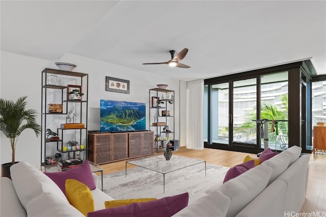 living room with ceiling fan, expansive windows, and hardwood / wood-style floors