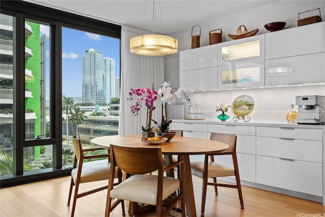 1108 Auahi St Unit 315, Honolulu, HI 96814 - dining area featuring light wood-style flooring, a wall of windows, and a city view