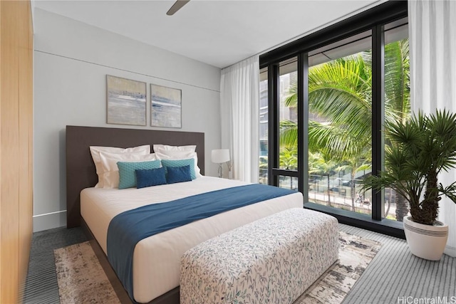 bedroom with ceiling fan, access to outside, and expansive windows