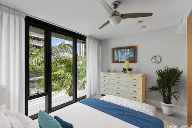 bedroom featuring ceiling fan, expansive windows, and access to exterior