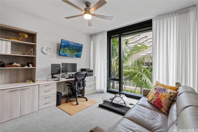 office space featuring ceiling fan and expansive windows