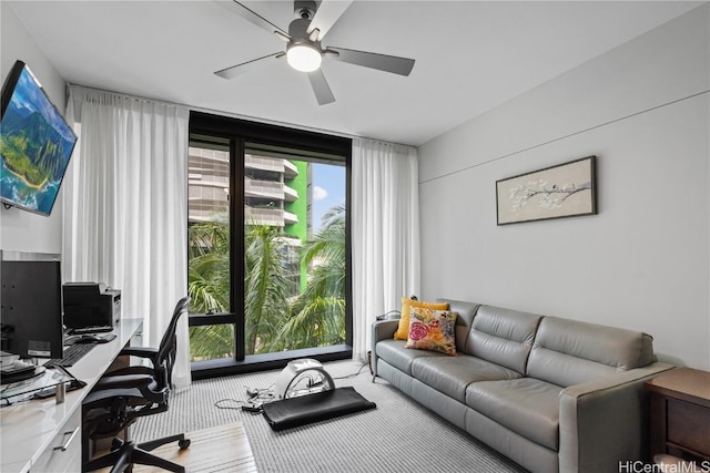 carpeted home office featuring ceiling fan and floor to ceiling windows