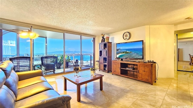 living room with a textured ceiling and floor to ceiling windows