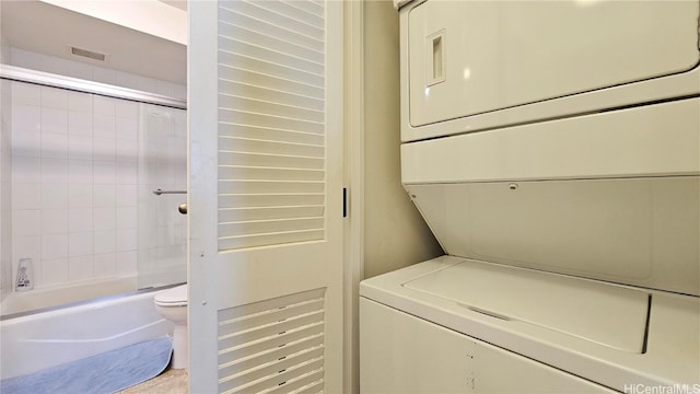 clothes washing area with stacked washer / dryer