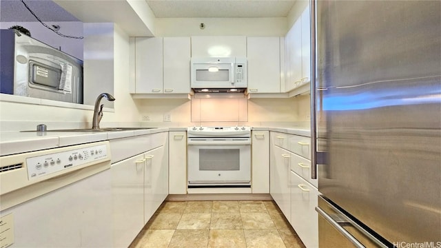 kitchen with sink, white appliances, and white cabinetry