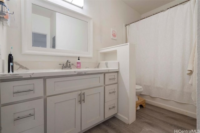 full bathroom featuring vanity, hardwood / wood-style floors, toilet, and shower / tub combo with curtain