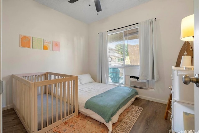 bedroom with dark hardwood / wood-style flooring, cooling unit, and ceiling fan