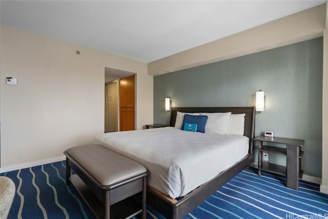 bedroom featuring baseboards and dark carpet