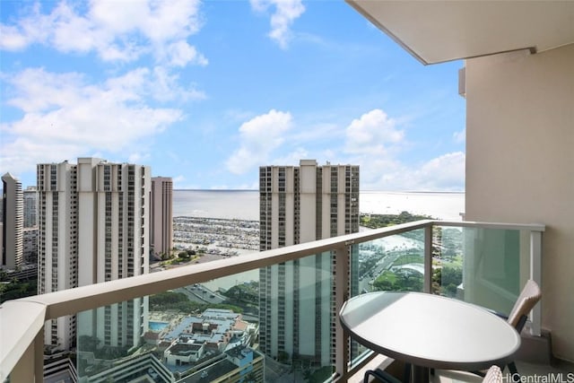 balcony with a water view and a view of city