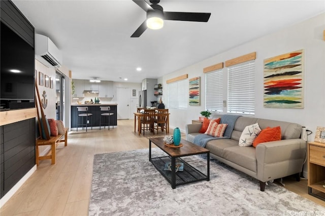 living room featuring ceiling fan, light hardwood / wood-style floors, and a wall mounted AC