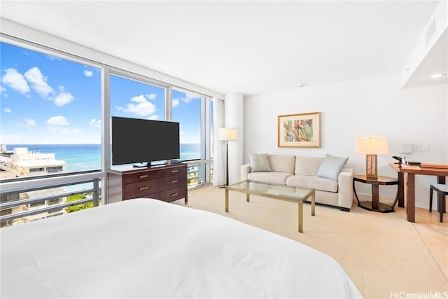 bedroom with a wall of windows, light carpet, and multiple windows