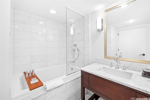 bathroom featuring vanity and tiled shower / bath