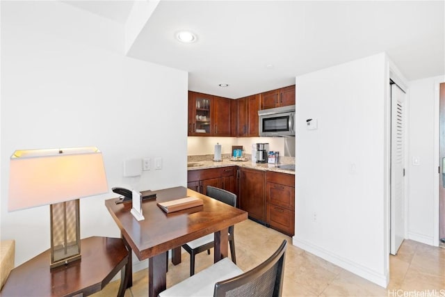 kitchen featuring light tile patterned flooring and light stone countertops