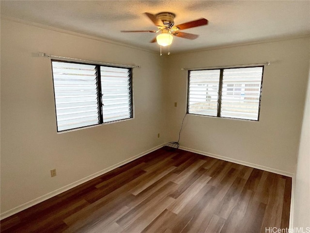 spare room featuring dark wood-type flooring and ceiling fan