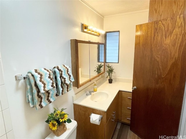 bathroom featuring vanity, ornamental molding, and toilet