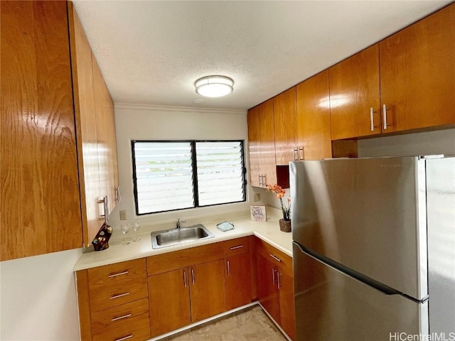 kitchen with sink, stainless steel fridge, and a textured ceiling