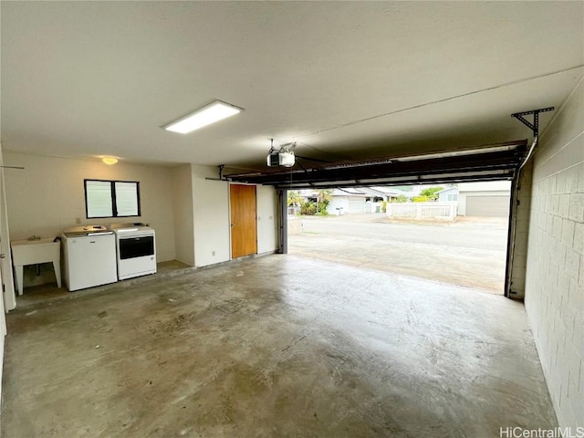 garage featuring a garage door opener, sink, and washer and dryer